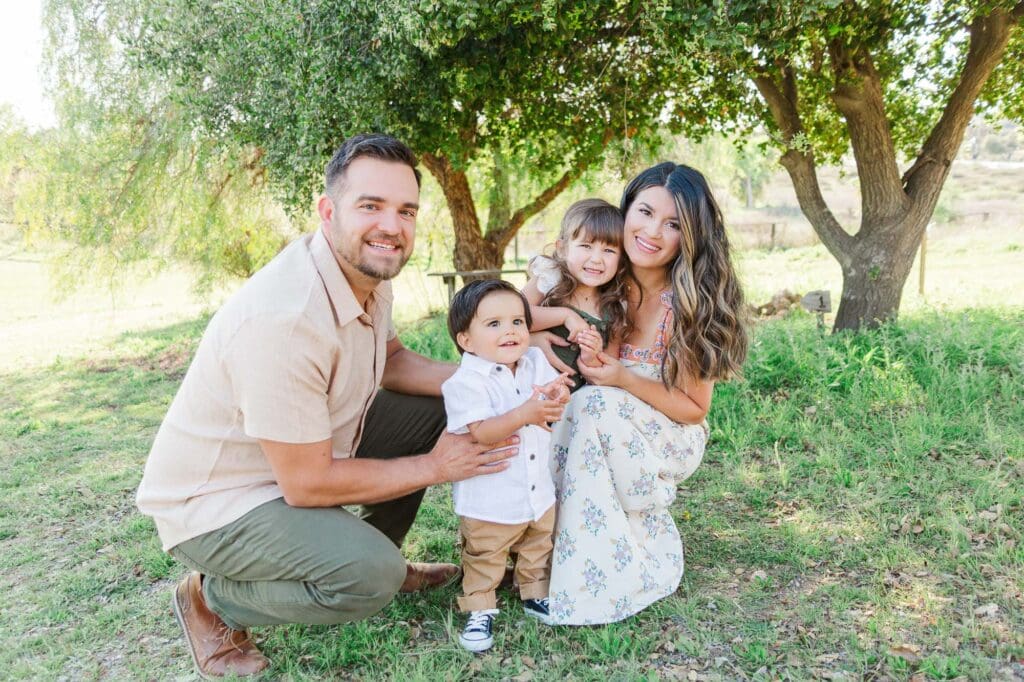 Family of four are smiling at the camera.
