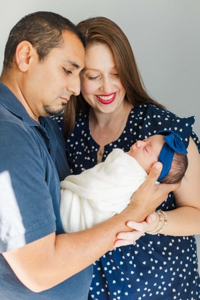 dad holding baby while both mom and dad are looking at baby