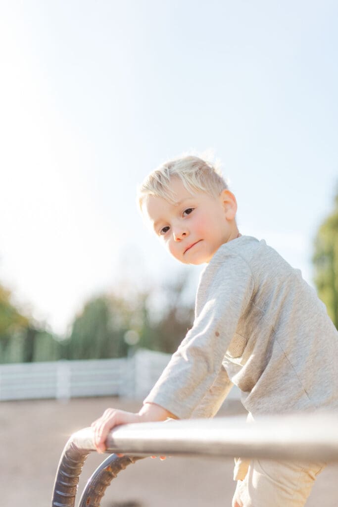 A quiet, authentic moment of a shy boy looking into the camera during a comfortable, stress-free family session in Temecula.