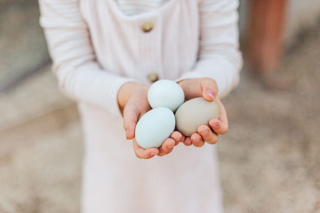 young child excitedly holding Easter eggs during a local Murrieta egg hunt, capturing the small, authentic joys of the holiday.